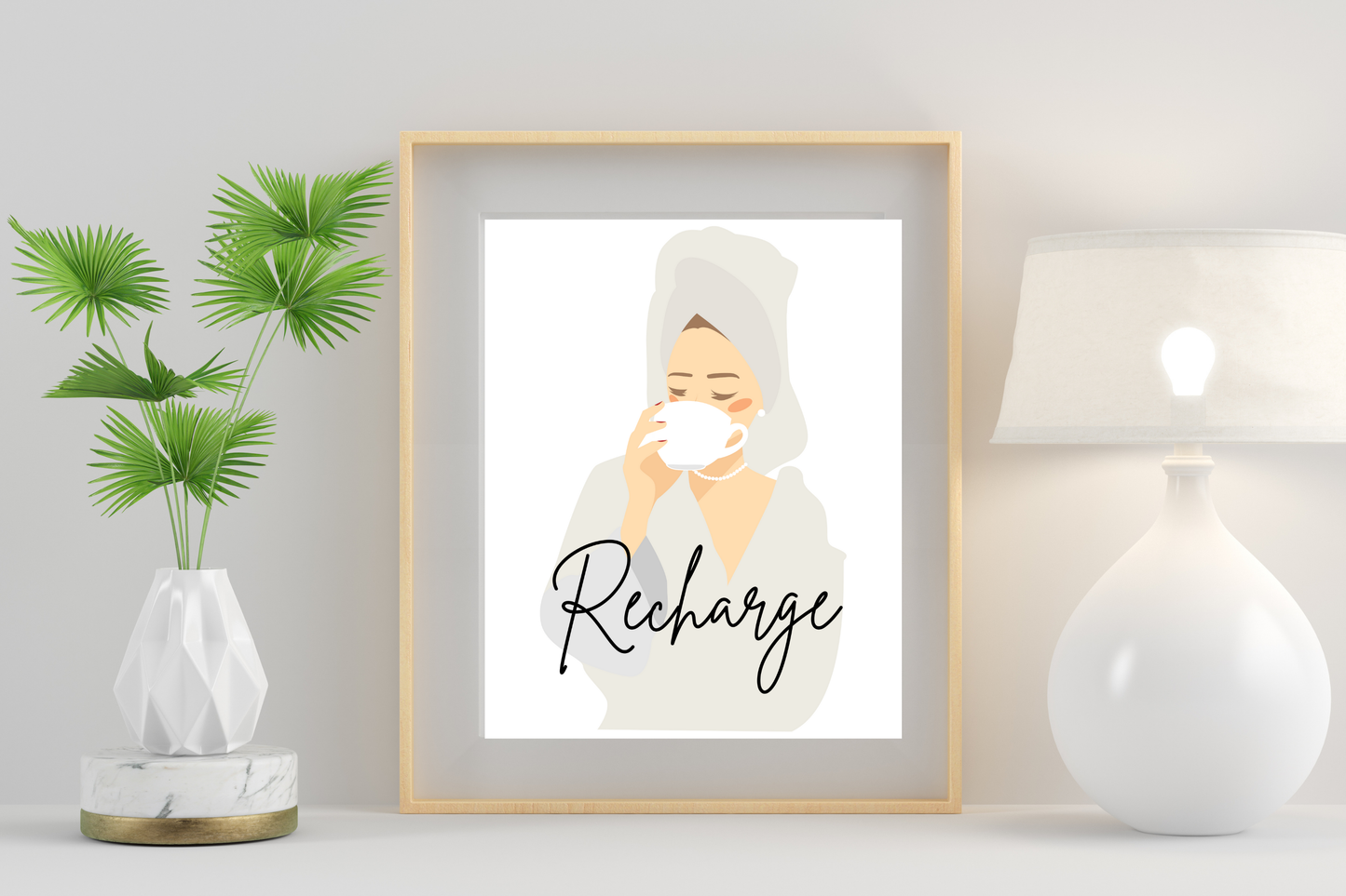 Framed artwork of a woman with a towel on her head and the word 'Recharge' in a home setting.