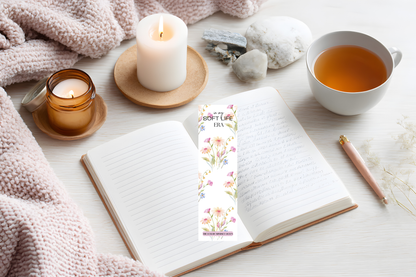 Printable floral bookmark with “In My Soft Life Era” text placed on top of an open reading notebook with calming tones.