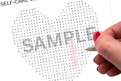 Hand holding a pen over a self-care word search puzzle