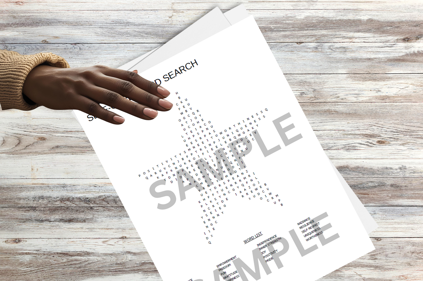 Woman's hand on a minimalist star-shaped word search on a wooden surface.